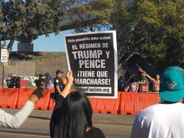 A woman holds a sign saying, "El Régimen de Trump y Pence ¡Tiene Que Marcharse! (The regime of Trump and Pence has to go!”. Photo Credit: Roberto A. Camacho